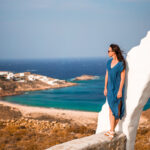 Young woman and traditional white church with sea view in Mykonos island,Greece