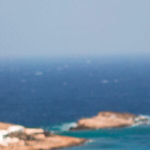 Young woman and traditional white church with sea view in Mykonos island,Greece